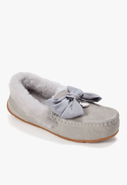 Light grey suede moccasin slipper with soft shearling lining and a grey bow accent.