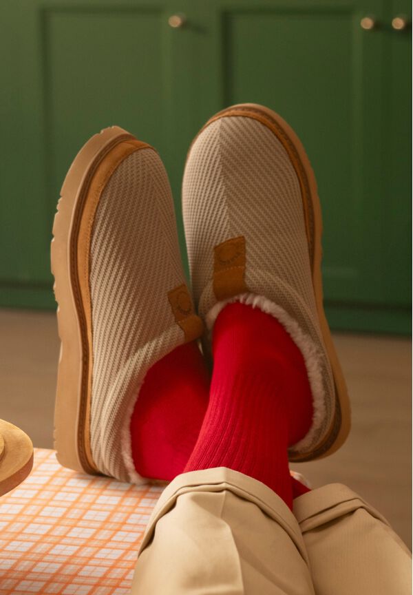 Men&rsquo;s tan slip-on shoes with gum soles, worn with bright red socks.