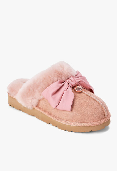 Dusty pink suede mule slipper with plush pink shearling trim and a satin bow detail.