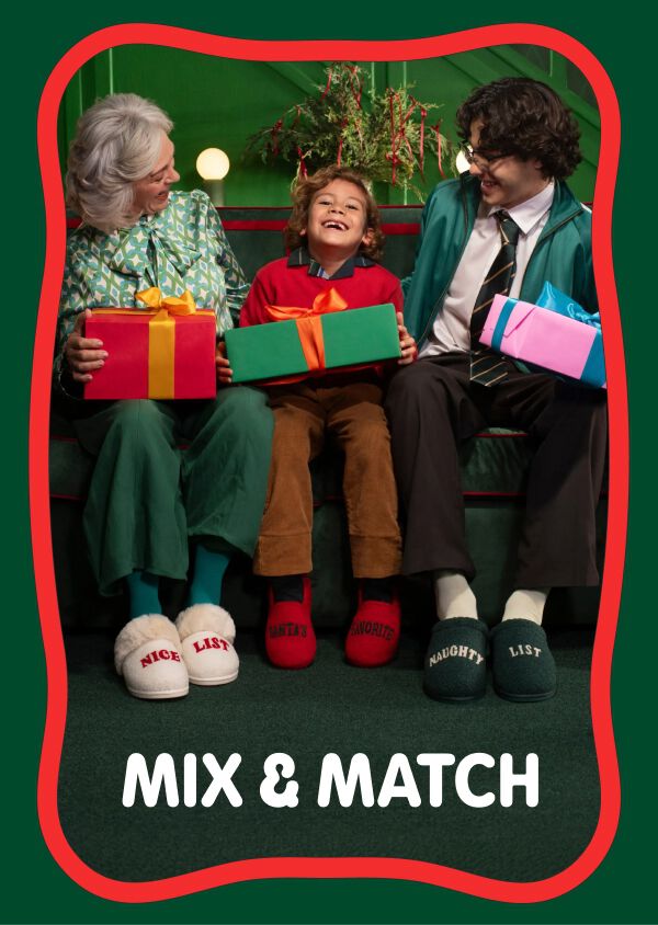 Family wearing coordinating holiday slippers and holding colorful gifts. Mix & Match.