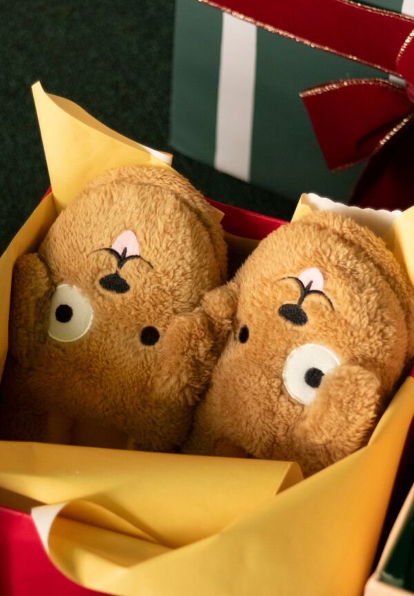 Kids&rsquo; dog slippers nestled together in a holiday gift box.