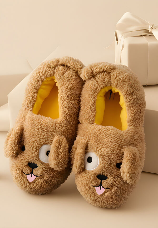 A pair of plush slippers designed to look like cartoon dogs with floppy ears and protruding tongues, placed next to wrapped gift boxes.